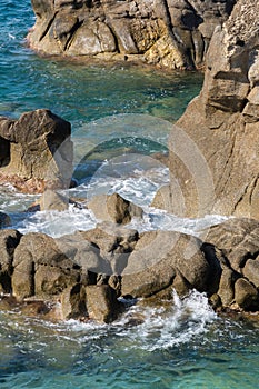 Waves on rocky beach, sea shore with waves crushing over the big rocks