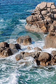 Waves on rocky beach, sea shore with waves crushing over the big rocks