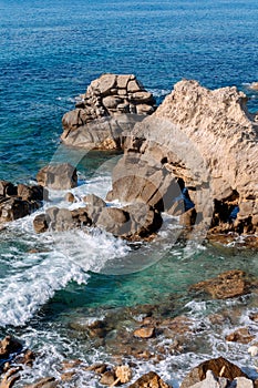 Waves on rocky beach, sea shore with waves crushing over the big rocks