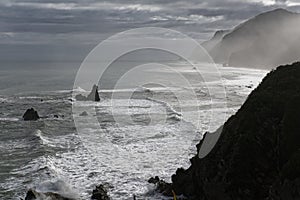 Waves roll over large rocky outcrops in the ocean careening in to shore photo