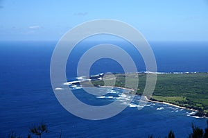 Waves roll towards Kalaupapa Peninsula with airport and Lighthouse