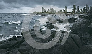 Waves of rough sea are breaking on rocky shore. Horizontal layout