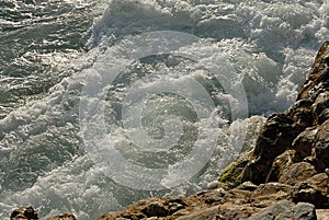 Waves rumbling against the rocky shore.