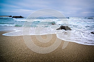 Waves rush onto the sandy beach in San Diego photo