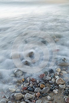 Ondas apurado través de piedras sobre el Playa 