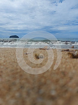 Waves and sandy beaches grace the land, while sky and clouds grace the skies