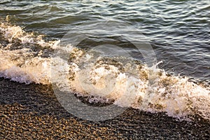 Waves at sea in the rays of sunset