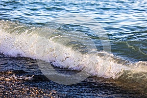 Waves at sea in the rays of sunset