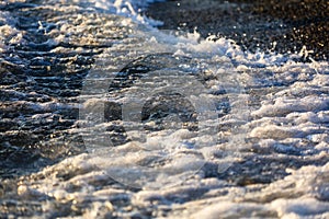 Waves at sea in the rays of sunset