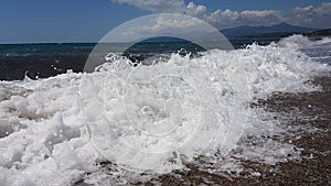 Waves splash foam in summer sea Preveza Greece
