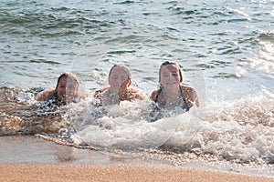 Waves Splash Girls Laying on the Sand