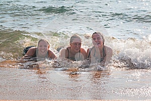 Waves Splash Girls Laying on the Sand