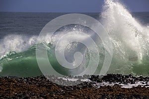 Waves splashing on basalt rocks at Ocean beach Bunbury Western Australia photo