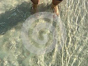 Waves splashing over feet in the emerald green waters of the Gulf of Mexico at Rosemary Beach, Florida