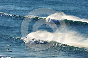 Waves spraying and surfers