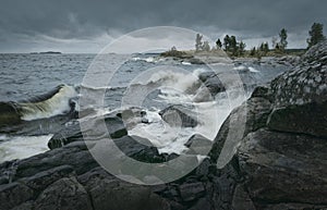 Waves of stormy sea break on rocky shore. Horizontal layout