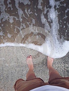 Waves trying to chase toes in the sand