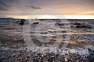 Waves wash ashore at sunset