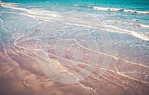 Waves washing ashore on the washed-out sand photo