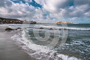 Waves washing onto beach at Ile Rousse in Corsica