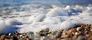 Waves washing over gravel beach, macro shot.