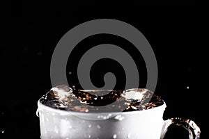 Waves of water on the surface of the cup on a black background