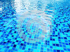 Waves on the water surface The water ripples in the pool and overlooking blurred bright blue ceramic tiles that cover