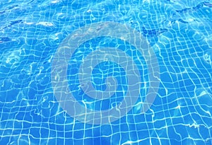 Waving blue swimming pool rippled water surface background.