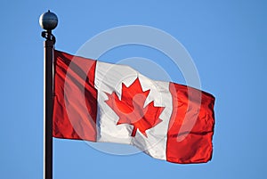 Waving Canadian flag against blue sky