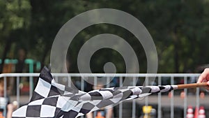 Waving checkered race flag close up. Flag which announces the final lap of the race on a finish line