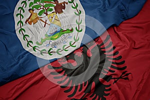 waving colorful flag of albania and national flag of belize