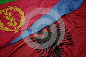 waving colorful flag of albania and national flag of eritrea