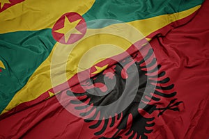 waving colorful flag of albania and national flag of grenada