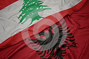 waving colorful flag of albania and national flag of lebanon