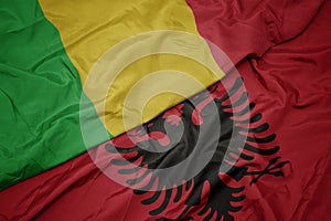 waving colorful flag of albania and national flag of mali