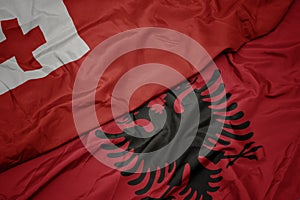 waving colorful flag of albania and national flag of Tonga