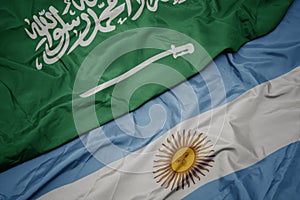 waving colorful flag of argentina and national flag of saudi arabia