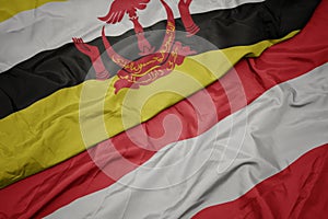 waving colorful flag of austria and national flag of brunei