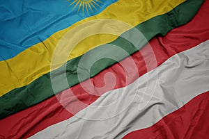 waving colorful flag of austria and national flag of rwanda