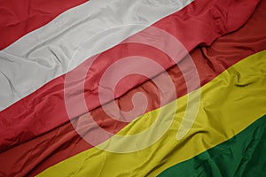 waving colorful flag of bolivia and national flag of austria