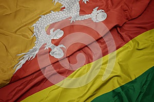 waving colorful flag of bolivia and national flag of bhutan