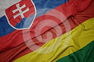 Waving colorful flag of bolivia and national flag of slovakia