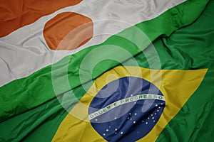waving colorful flag of brazil and national flag of niger photo