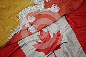 waving colorful flag of canada and national flag of bhutan