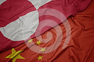 waving colorful flag of china and national flag of greenland