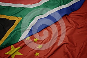 waving colorful flag of china and national flag of south africa