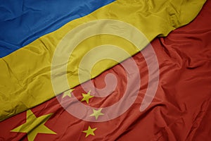 waving colorful flag of china and national flag of ukraine