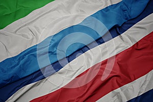 waving colorful flag of costa rica and national flag of sierra leone