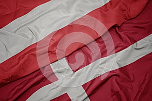 waving colorful flag of denmark and national flag of austria