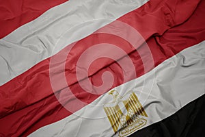 waving colorful flag of egypt and national flag of austria